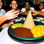 A diverse group of adults and families gathered around a traditional low table in an authentic Ethiopian restaurant. They are sharing a large injera platter piled with an assortment of vibrantly colored wots, including red Key Wat, orange Misir Wat, and green Gomen. Hands are gracefully reaching for the food, some performing a Gursha gesture, symbolizing hospitality. The atmosphere is warm, inviting, and filled with genuine connection. All subjects are fully clothed in modest, appropriate attire. safe for work, appropriate content, family-friendly, perfect anatomy, correct proportions, natural pose, well-formed hands, proper finger count, natural body proportions, professional photography, high quality, ultra-realistic.